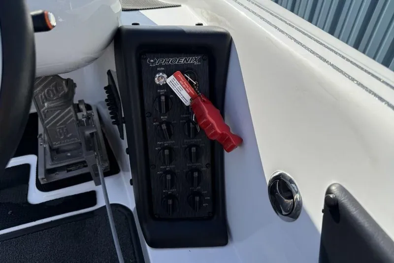 Slide: The Image of Control panel of 2019 Phoenix 618 Pro boat with switches and red safety key. - 6