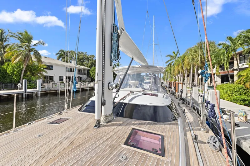 Slide: The Image of Sailing yacht Hylas 63, 2013 model, docked by palm trees and waterfront homes. - 1