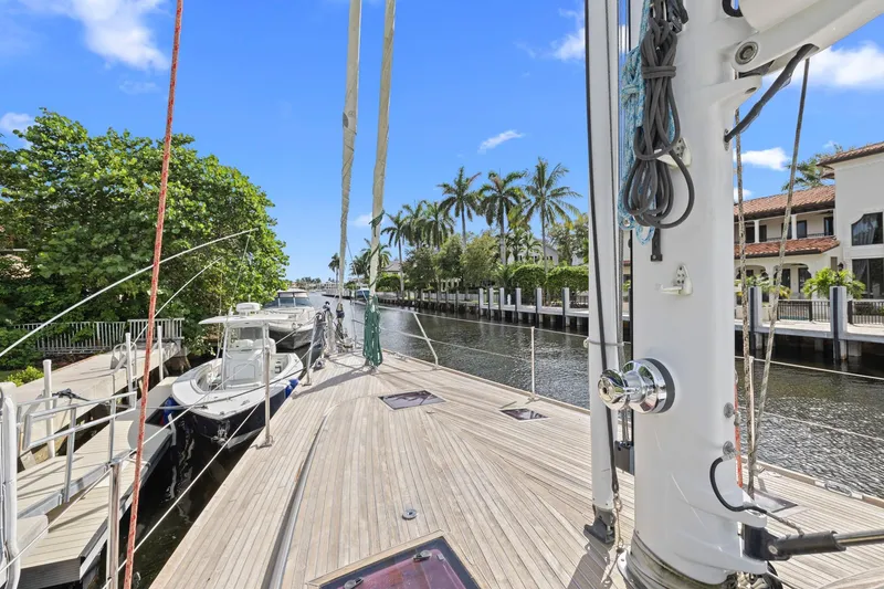 Slide: The Image of Sailboat docked in a scenic canal, surrounded by palm trees and luxury homes. - 35
