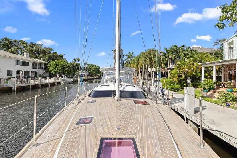 Slide: The Image of 2013 Hylas 63 yacht docked in a scenic canal with palm trees and houses. - 36