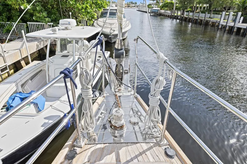 Slide: The Image of Bow view of a 2013 Hylas 63 yacht docked in a serene canal setting. - 37