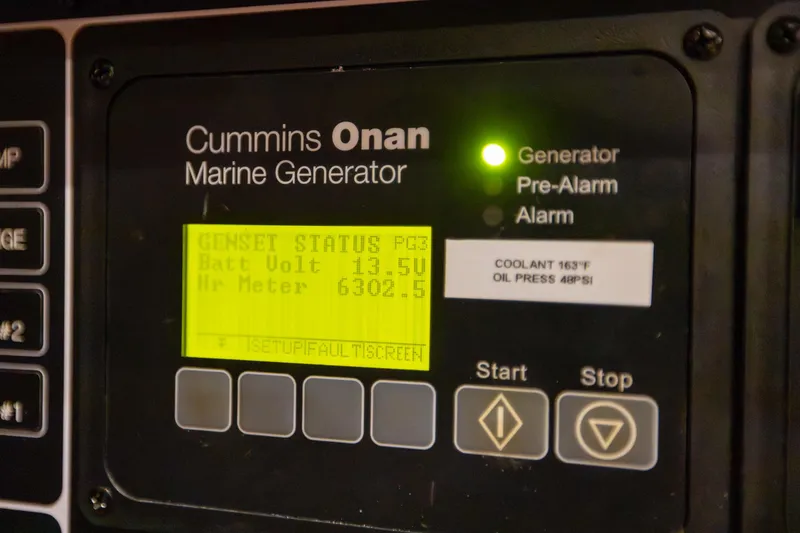 Slide: The Image of Cummins Onan marine generator display on a 2013 Hylas 63 yacht, showing status and metrics. - 64