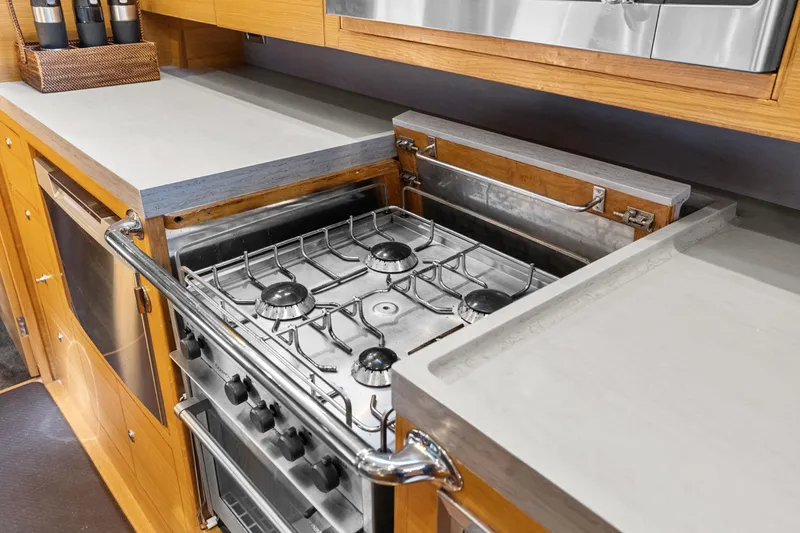 Slide: The Image of Modern kitchen in 2013 Hylas 63 yacht with stainless steel stove and wooden cabinetry. - 65