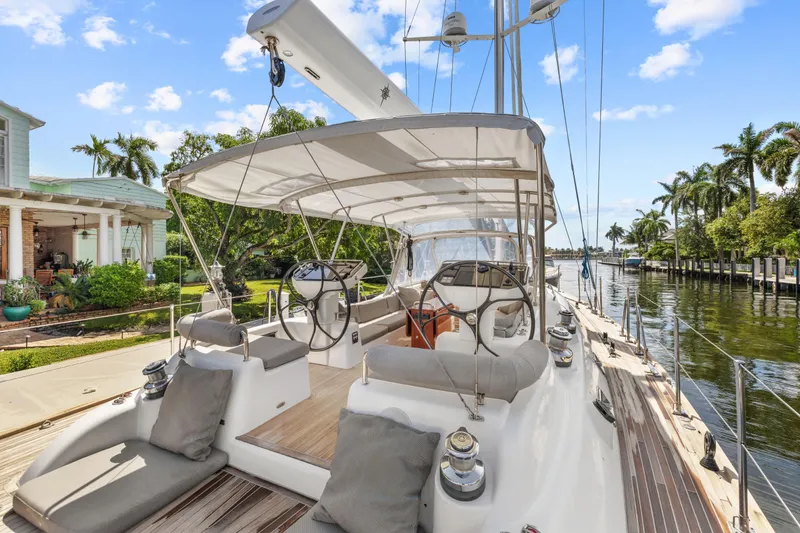 Slide: The Image of Luxurious 2013 Hylas 63 yacht docked by a waterfront home, featuring spacious deck and helm. - 76