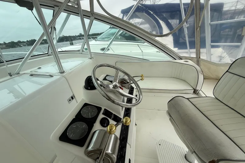 Slide: The Image of 2003 Luhrs 32 Open boat cockpit with steering wheel and seating area. - 11