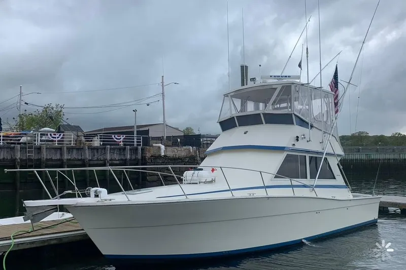 The Image of 1986 Viking 35 Convertible boat docked under cloudy skies. - 0