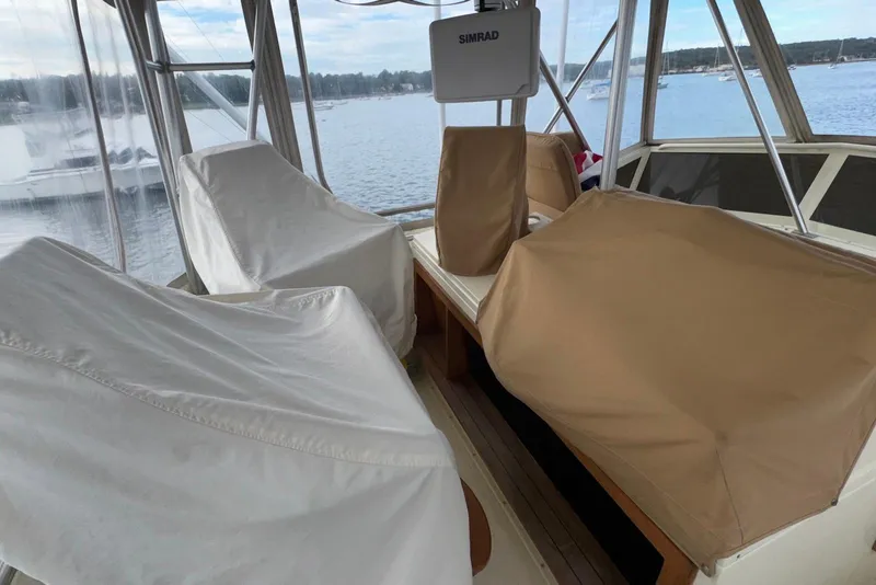 Slide: The Image of 1986 Viking 35 Convertible boat interior with covered seating and Simrad equipment. - 13