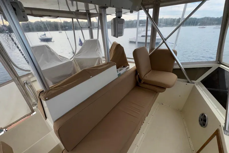 Slide: The Image of 1986 Viking 35 Convertible boat interior with tan seating and lake view. - 15