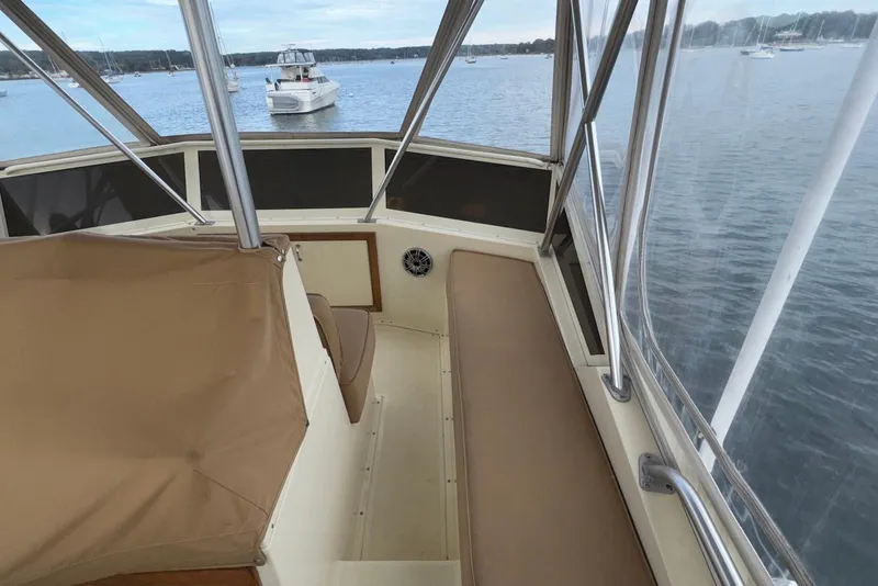 Slide: The Image of 1986 Viking 35 Convertible boat interior with beige seating, overlooking a serene lake. - 16