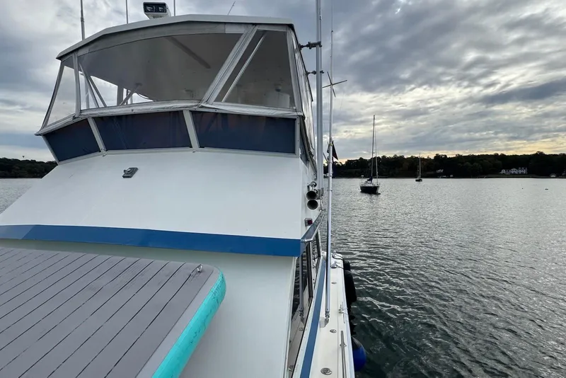 Slide: The Image of 1986 Viking 35 Convertible boat on calm water under cloudy sky. - 19