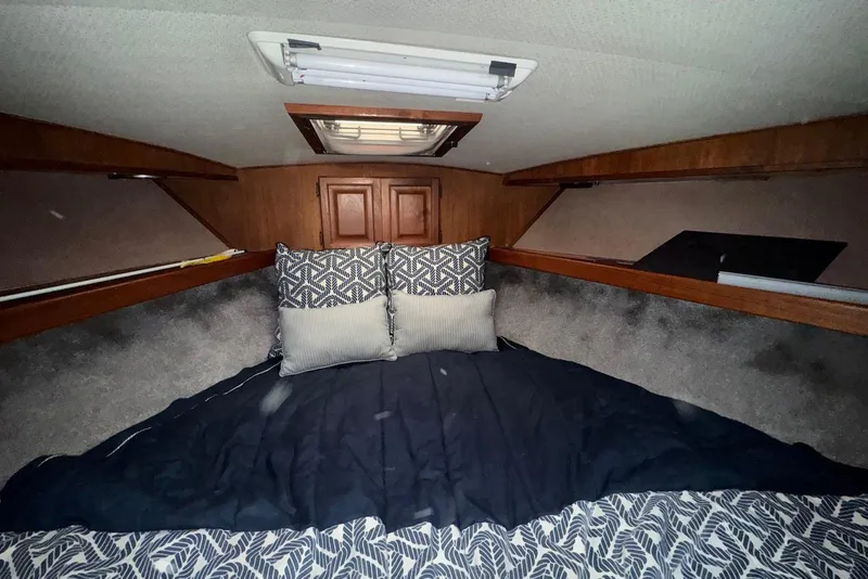Slide: The Image of Cozy cabin interior of 1986 Viking 35 Convertible with patterned bedding and wooden accents. - 24