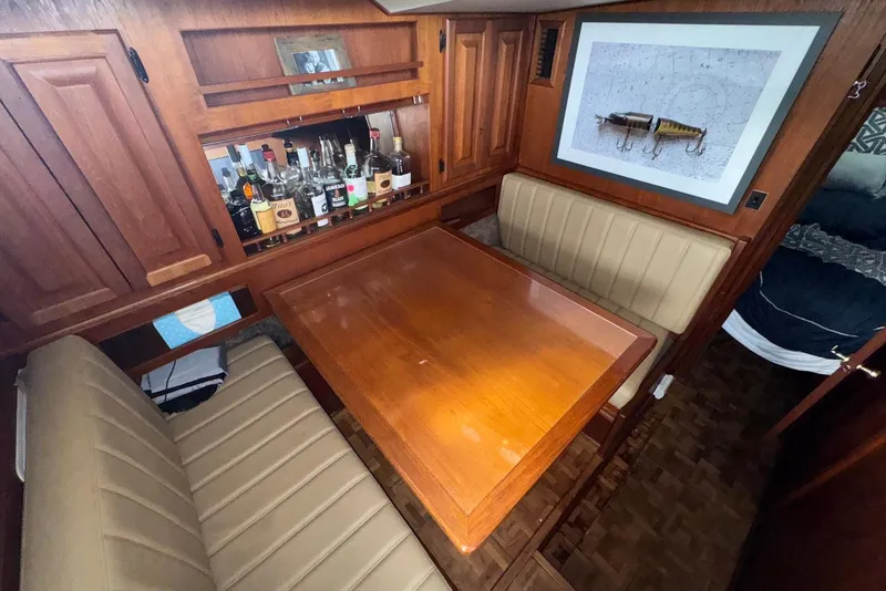 Slide: The Image of 1986 Viking 35 Convertible interior with dining area, wooden table, and bar setup. - 26