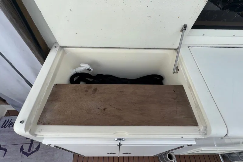 Slide: The Image of Storage compartment on a 1986 Viking 35 Convertible boat with wooden cover and faucet. - 29