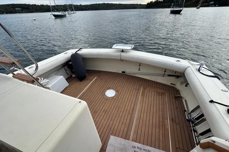 Slide: The Image of 1986 Viking 35 Convertible boat deck with wooden flooring, overlooking a serene lake. - 32