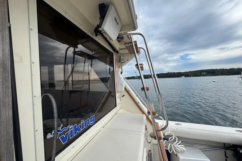 Slide: The Image of 1986 Viking 35 Convertible boat on calm water, featuring sleek design and scenic view. - 33