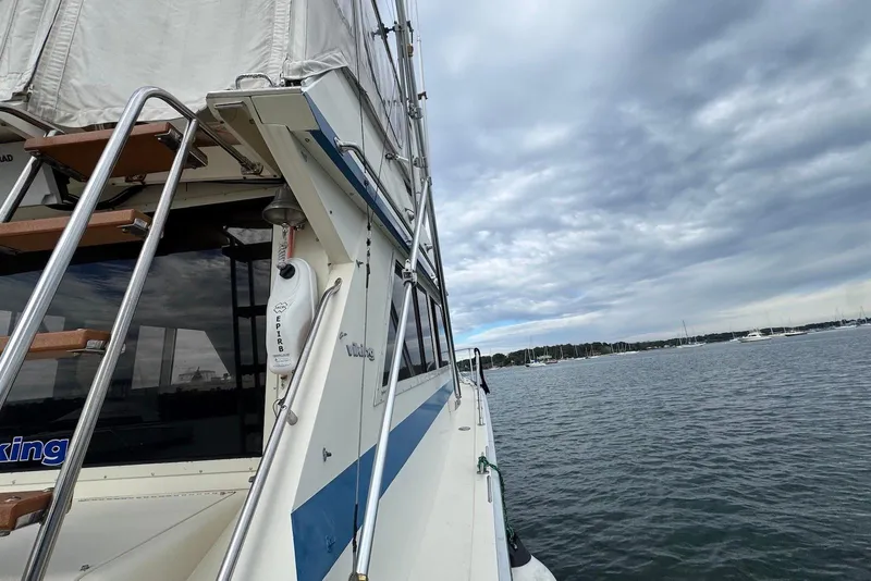 Slide: The Image of 1986 Viking 35 Convertible boat on water under cloudy sky. - 34