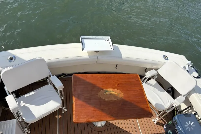 Slide: The Image of 1986 Viking 35 Convertible boat deck with chairs and wooden table, overlooking water. - 40
