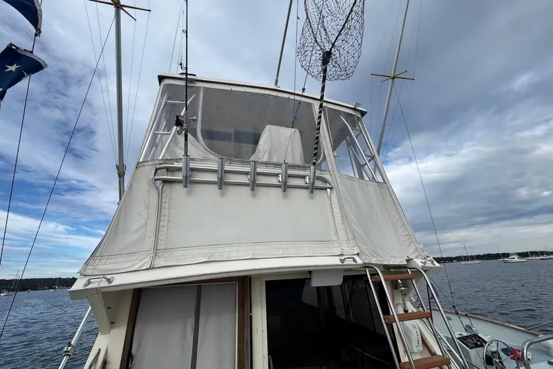 Slide: The Image of 1986 Viking 35 Convertible boat with fishing gear, docked under cloudy skies. - 7