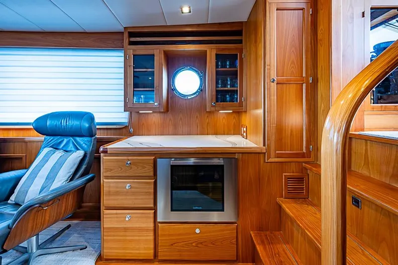 Slide: The Image of Luxurious 2019 Kadey-Krogen 44 AE yacht interior with wood cabinetry and blue leather chair. - 15