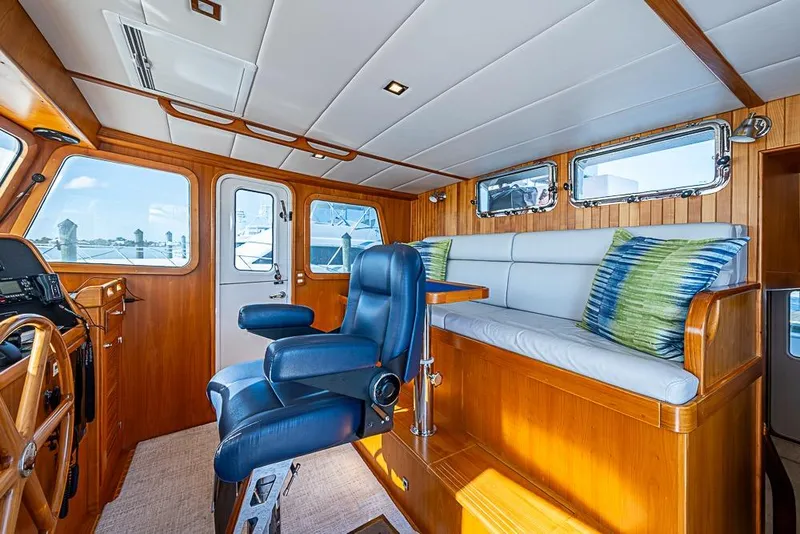 Slide: The Image of 2019 Kadey-Krogen 44 AE yacht interior with helm, seating, and wood paneling. - 25