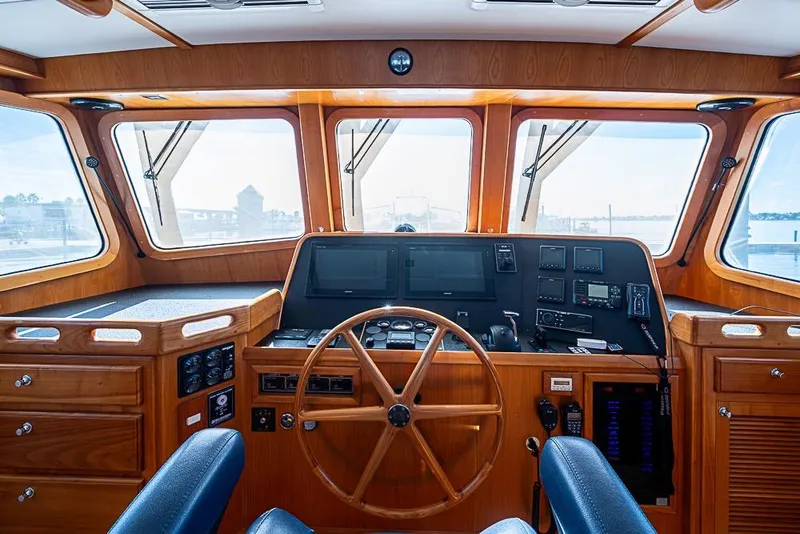 Slide: The Image of 2019 Kadey-Krogen 44 AE yacht helm with wooden finish and navigation equipment. - 26