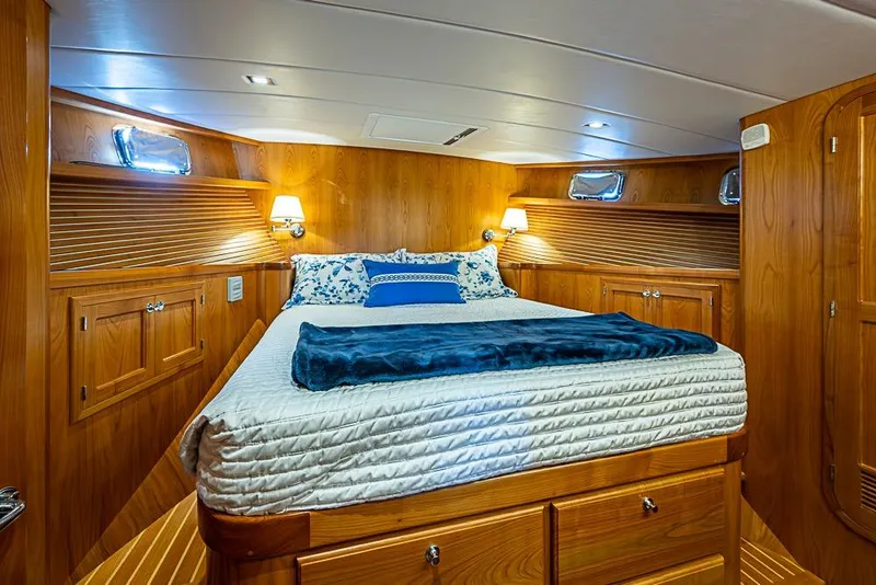 Slide: The Image of Luxurious 2019 Kadey-Krogen 44 AE yacht bedroom with wood paneling and cozy bedding. - 27