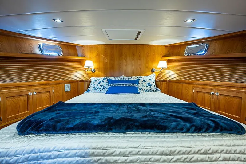 Slide: The Image of Luxurious 2019 Kadey-Krogen 44 AE yacht bedroom with wood paneling and cozy bedding. - 28