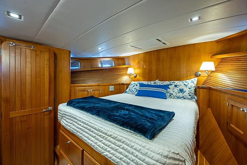 Slide: The Image of Luxurious 2019 Kadey-Krogen 44 AE yacht bedroom with wood paneling and cozy bedding. - 29