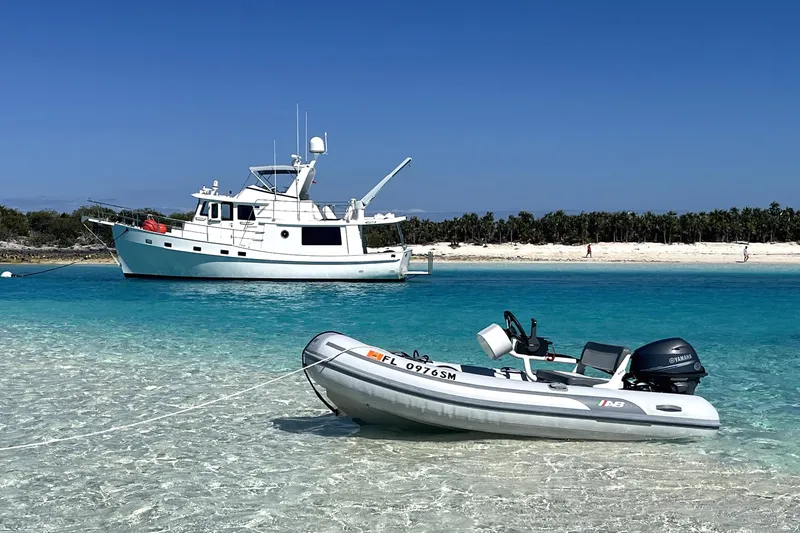 Slide: The Image of 2019 Kadey-Krogen 44 AE yacht anchored near a sandy beach with a small dinghy. - 8