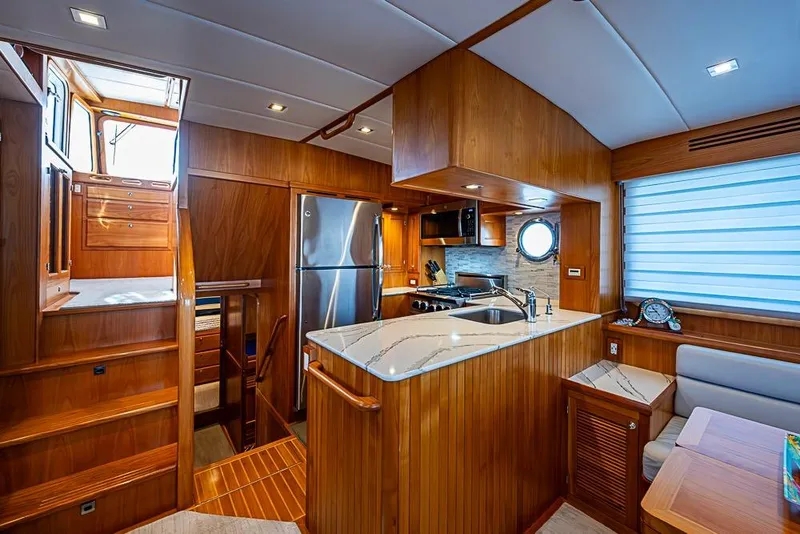 Slide: The Image of Luxurious 2019 Kadey-Krogen 44 AE yacht interior with modern kitchen and wooden finishes. - 16