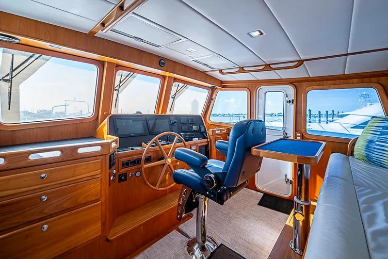 Slide: The Image of 2019 Kadey-Krogen 44 AE yacht interior with helm, wooden cabinetry, and blue seating. - 20