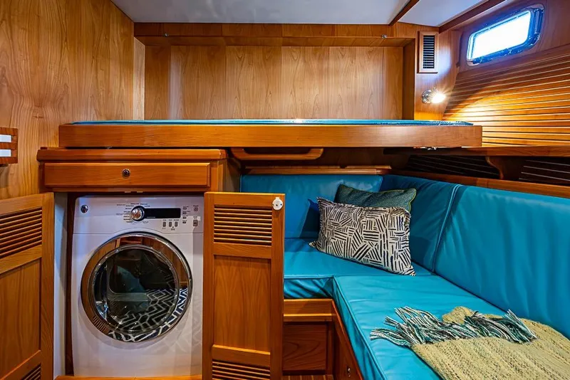 Slide: The Image of 2019 Kadey-Krogen 44 AE yacht interior with washer, teal seating, and wooden cabinetry. - 38