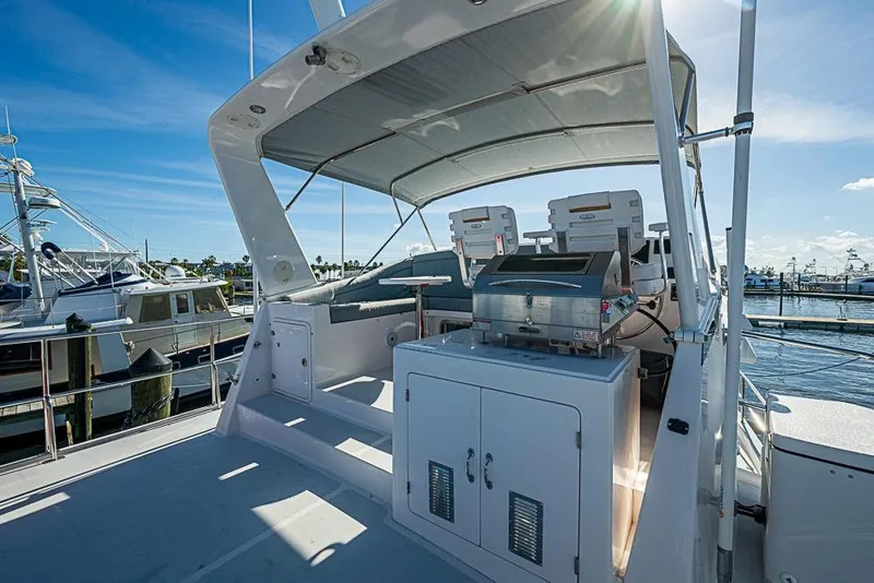 Slide: The Image of 2019 Kadey-Krogen 44 AE yacht deck with seating and grill under canopy. - 52