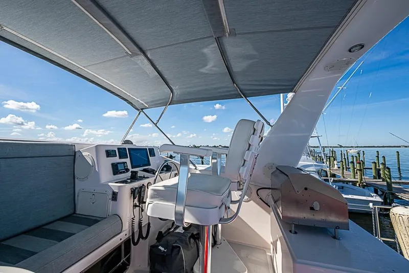 Slide: The Image of Flybridge of 2019 Kadey-Krogen 44 AE yacht with helm station and seating, docked by the water. - 56