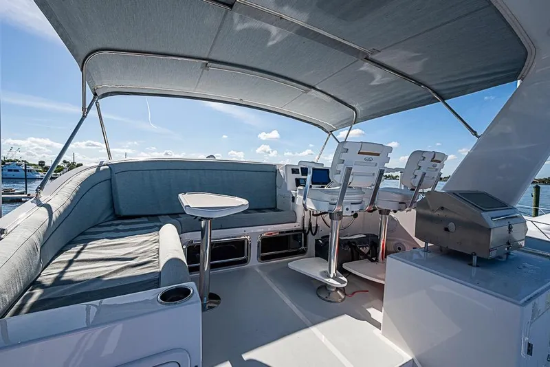 Slide: The Image of 2019 Kadey-Krogen 44 AE yacht deck with seating, helm, and grill under canopy. - 59