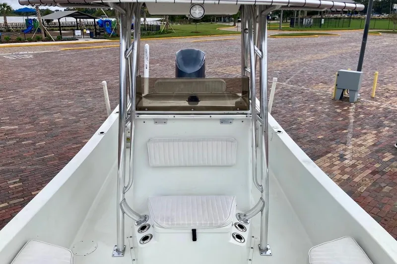 Slide: The Image of 2007 Action Craft Coastal Bay 2310 boat interior with seating and console, parked on brick pavement. - 24