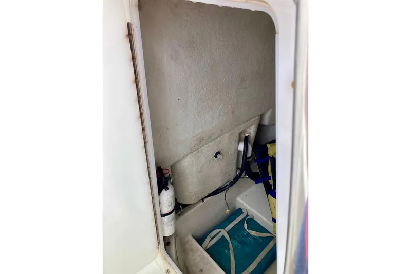 Slide: The Image of 2007 Action Craft Coastal Bay 2310 storage compartment with fire extinguisher and gear. - 38