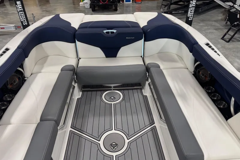 Slide: The Image of 2019 MasterCraft XT25 boat interior with gray and white seating, stylish flooring, and cup holders. - 12