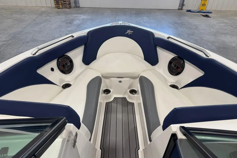 Slide: The Image of 2019 MasterCraft XT25 boat interior with blue and white seating, cup holders, and speakers. - 15