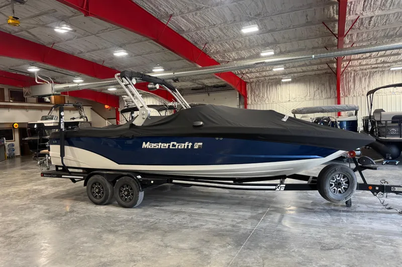 Slide: The Image of 2019 MasterCraft XT25 boat with cover in a showroom. - 17