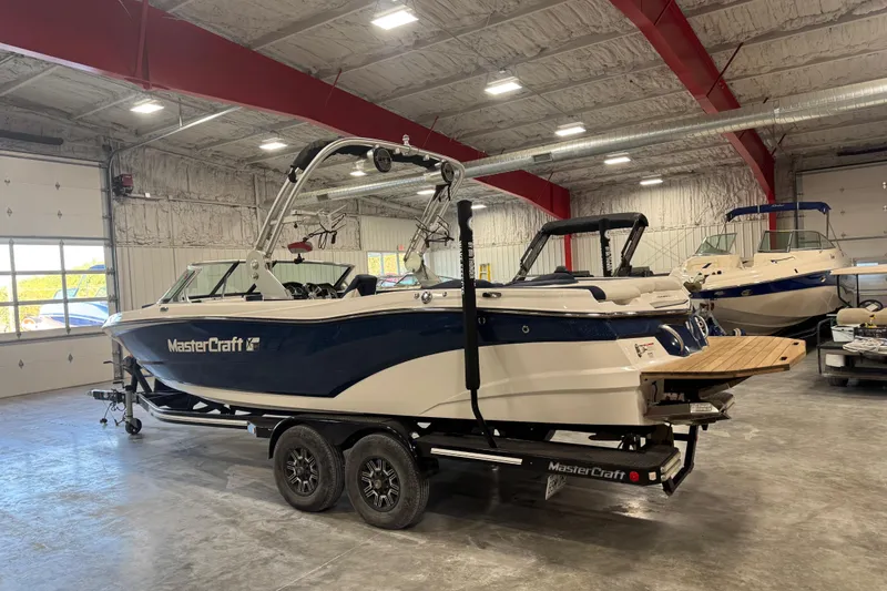 Slide: The Image of 2019 MasterCraft XT25 boat in a warehouse, showcasing sleek design and modern features. - 3