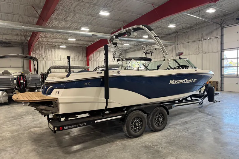 Slide: The Image of 2019 MasterCraft XT25 boat in a showroom, blue and white design on a trailer. - 4