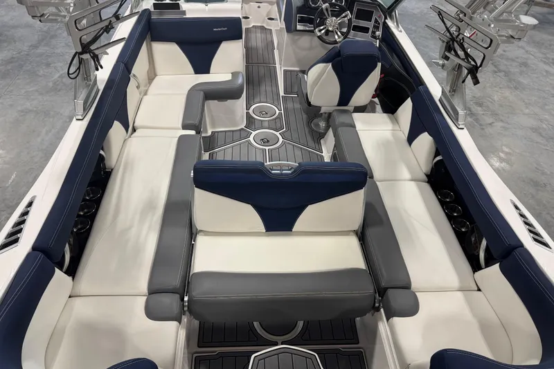 Slide: The Image of 2019 MasterCraft XT25 boat interior with blue and white seating, modern design, and spacious layout. - 8