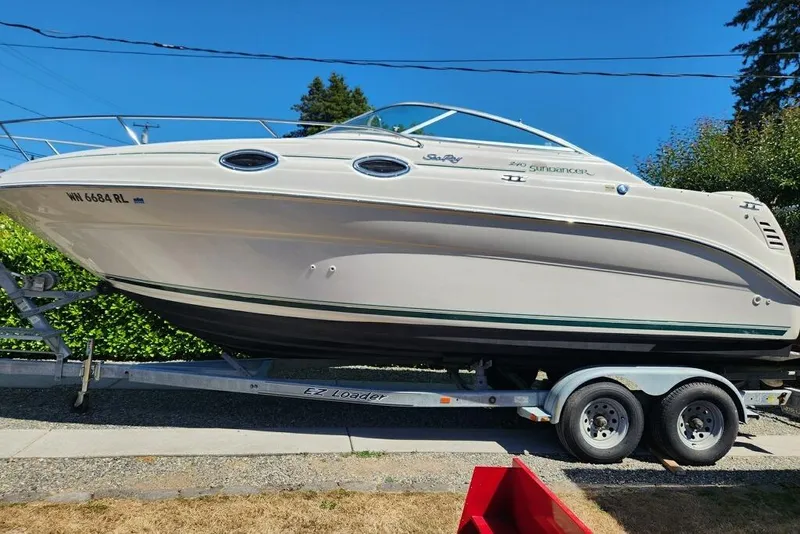The Image of 2000 Sea Ray 240 Sundancer boat in a storage facility, showcasing sleek design and interior. - 0