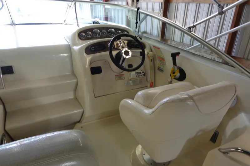 Slide: The Image of 2000 Sea Ray 240 Sundancer boat cockpit with steering wheel and control panel. - 12
