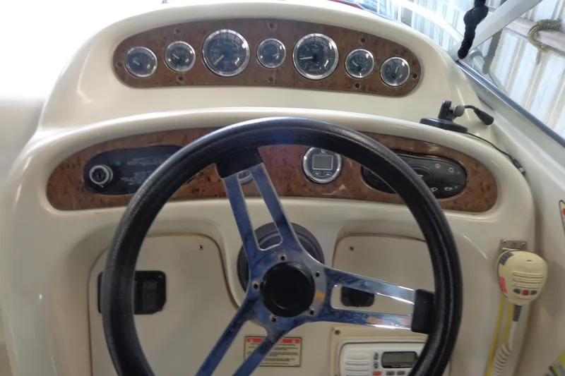Slide: The Image of Steering wheel and dashboard of a 2000 Sea Ray 240 Sundancer boat. - 13