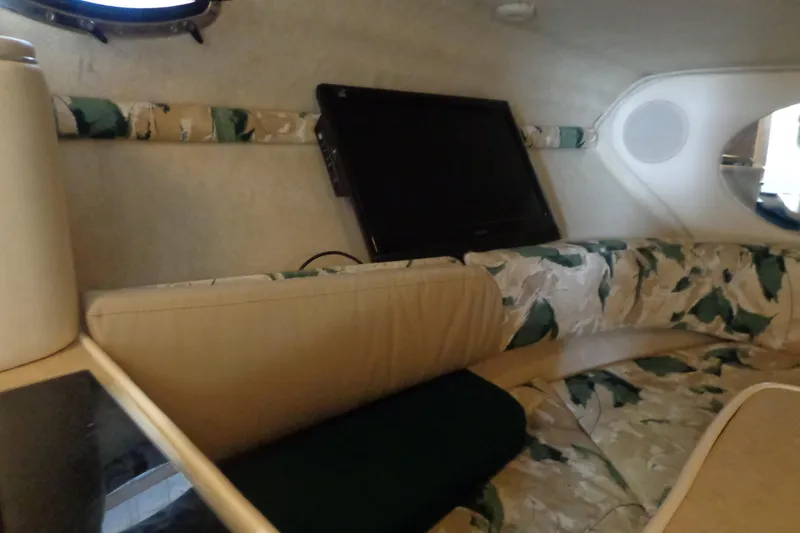 Slide: The Image of Interior of 2000 Sea Ray 240 Sundancer with patterned seating and mounted TV. - 17