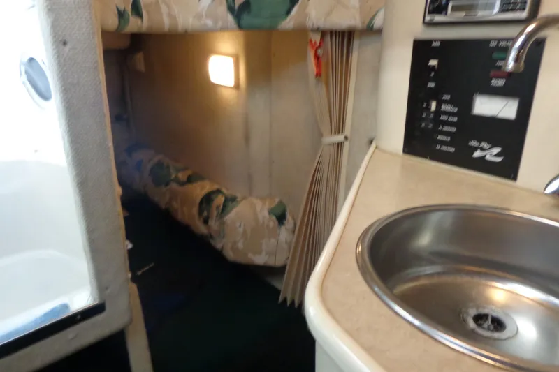 Slide: The Image of Interior of 2000 Sea Ray 240 Sundancer with sink and cozy sleeping area. - 18