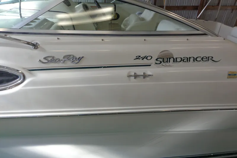Slide: The Image of 2000 Sea Ray 240 Sundancer boat docked in a covered marina. - 2