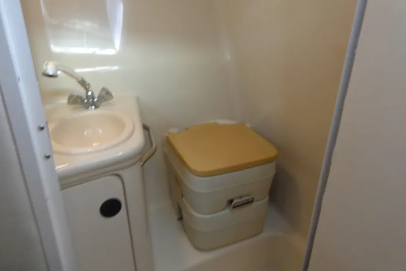 Slide: The Image of Compact bathroom in 2000 Sea Ray 240 Sundancer boat with sink and portable toilet. - 22